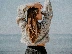 woman in white sweater and blue denim jeans standing on beach shore during daytime